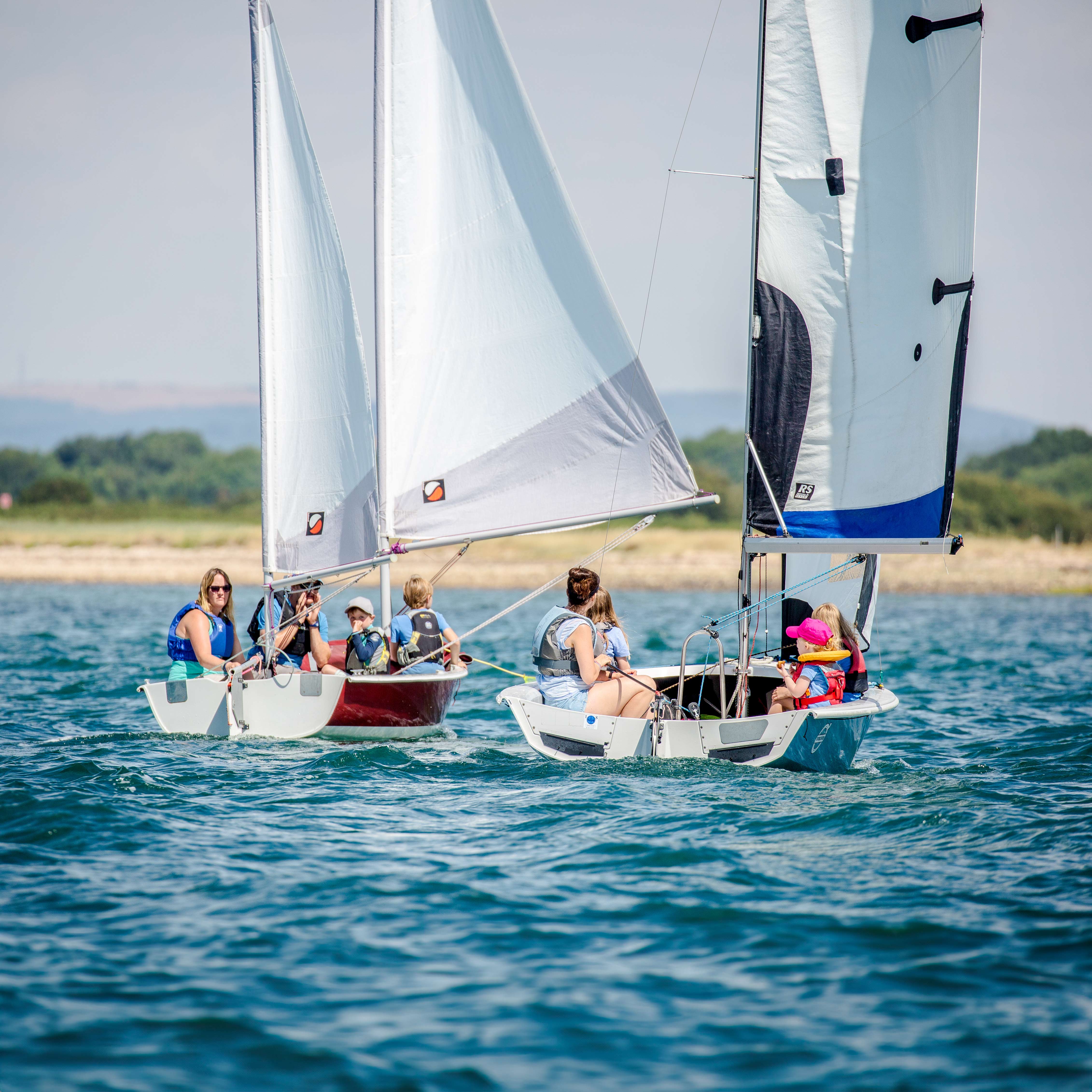 A large family sailing dingies on the water