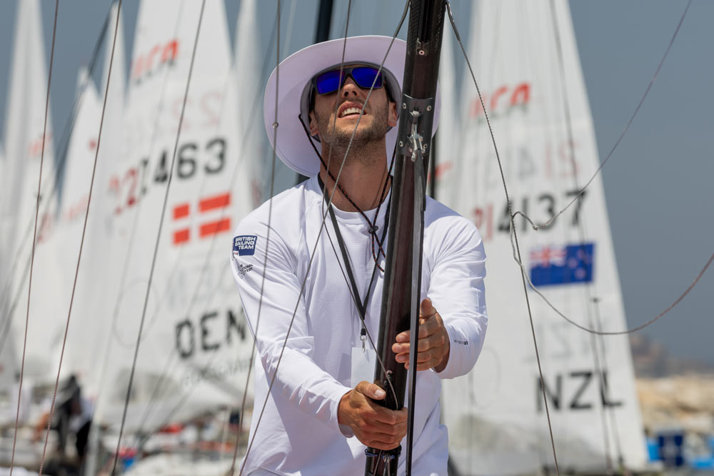 Flynn posing next to a sailing mast while wearing sun glasses